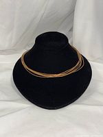 Front view of seven-strand gold-plated sterling silver necklace on display bust