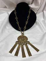 Full view of brass necklace on display bust