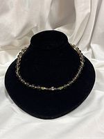 Necklace displayed on black bust showing bead arrangement