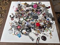Overall view of entire assorted jewelry spread on white surface