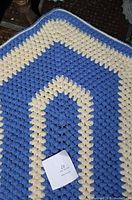 Oval blue and cream crocheted yarn rug close-up