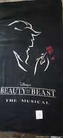 Full view of black towel with Beauty and the Beast The Musical logo