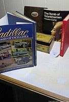 Front view showing both books, cigar box, wooden plaque
