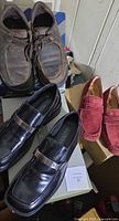 All three pairs: black loafers, brown Skechers, red Born loafers