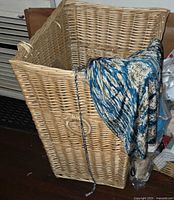 Tall light wicker hamper front and side view showing woven integrated handle and scale