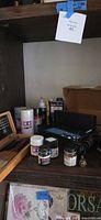 Shelf with Tamiya spray cans, paint jars, hose and flashlight