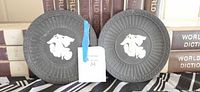 Two black jasperware plates side by side