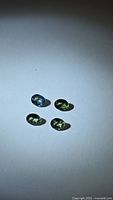 Four oval sapphires showing color mix under spotlight