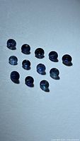 Group of 12 round blue sapphires on white background