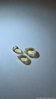 Three pale yellow pear cabochon citrines on light surface
