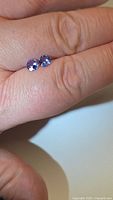 Both tanzanites side by side on fingertip