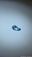 Single loose oval blue topaz on neutral background