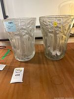 Two frosted glass vases side by side on table showing size and surface condition