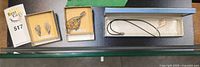 Overview showing earrings in box, leaf brooch in box, pearl pendant necklace in long box