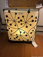 Front view of rectangular mid-century style lamp showing pattern and illumination