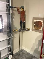 Full view of weathervane on rod against wall