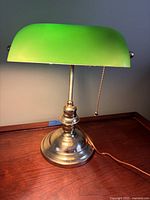 Front view of lamp showing green glass shade and brass base