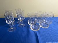 Group of four stemmed goblets and four tumblers on blue cloth