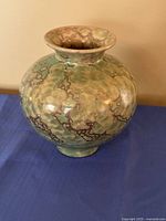 Full front view of green mottled ceramic vase