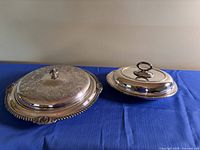 Both silver-plated pieces with lids in place displayed side by side