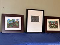 All three framed artworks on table