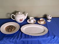 Group shot of all china pieces on blue cloth