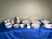Full set on table showing stacks of plates, cups, serving pieces