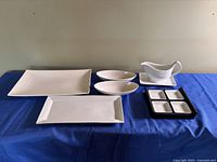 Group shot of all serving pieces on blue cloth