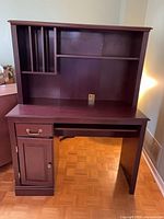 Front view of cherry desk with hutch showing drawer, cabinet, cubbies, work surface