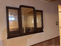 Front view of three-panel wooden mirror mounted on wall