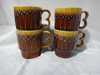 Four mugs stacked in two columns showing glaze and pattern