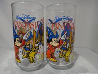 Front view of both tumblers showing Mickey Mouse and broomstick graphics