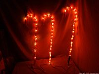 Three illuminated candy cane lights standing upright