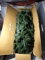 Box filled with green faux pine garland strands