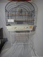 Bird cage mounted on stand showing overall appearance