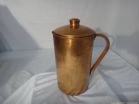 Front view of copper jug with lid and handle