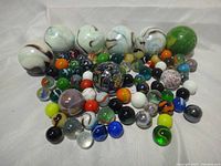 Group of marbles spread on cloth showing variety of sizes and colors