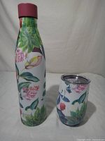 Water bottle and tumbler front view showing floral design and cap