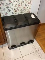 Front view of stainless steel 3-compartment trash can with lids closed