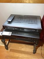 View of Sherwood amplifier stacked over Sony CD changer with remote on top