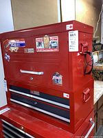 Front view of stacked red Craftsman top and middle toolboxes showing side handle and decals