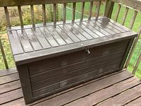 Front view of brown resin deck box on balcony