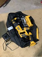 Soft bag holding multiple yellow/black DeWalt cordless tools, charger visible
