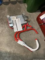 Ladder folded with instruction manual and hooks visible