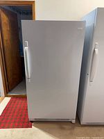 Front view of closed Frigidaire white upright refrigerator