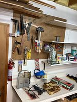 Overall view of peg-board tools, shelf items and countertop contents