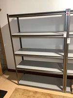 Front view of grey metal shelving rack showing five shelves