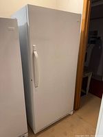 Front view of white Frigidaire upright freezer with handle