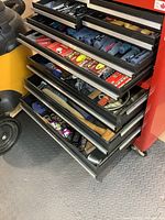 Multiple drawers of red rolling chest showing assorted hand tools