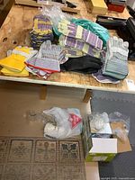 Assortment of gloves on bench, dust masks and ear plugs on floor